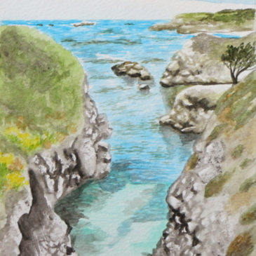Cove with bright blue water framed by rocky cliffs with grasses growing from them