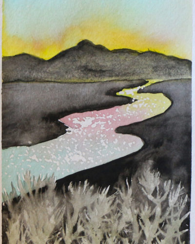 Sunset behind mountains with sky reflected in river and grass in foreground