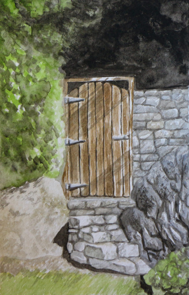 Wooden gate in stone wall with shadowy trees beyond