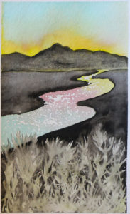 Sunset behind mountains with sky reflected in river and grass in foreground