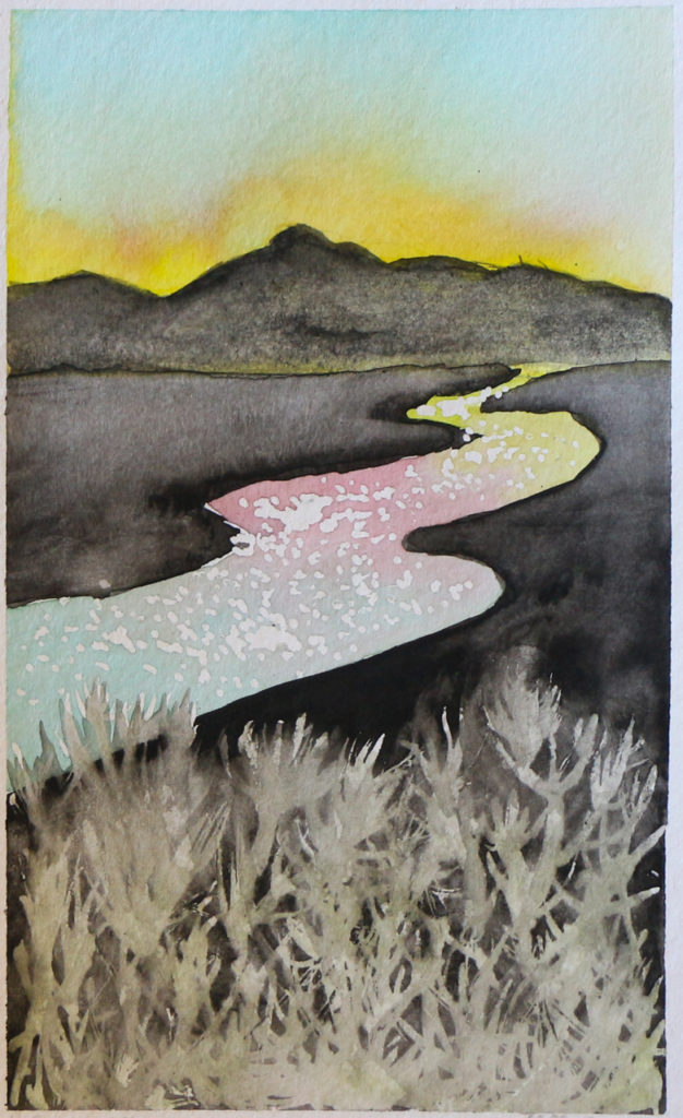 Sunset behind mountains with sky reflected in river and grass in foreground